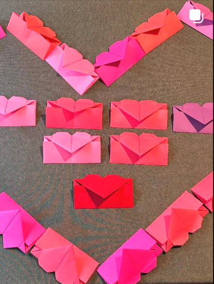 Handmade paper heart envelopes arranged in a heart shape